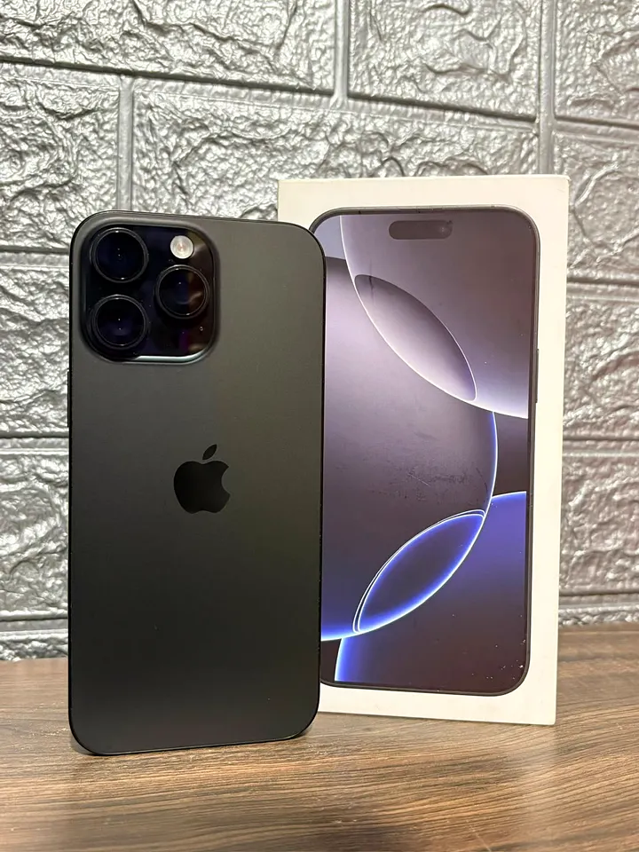 iPhone 16 Pro Max preto em pé ao lado da caixa, na bancada da loja