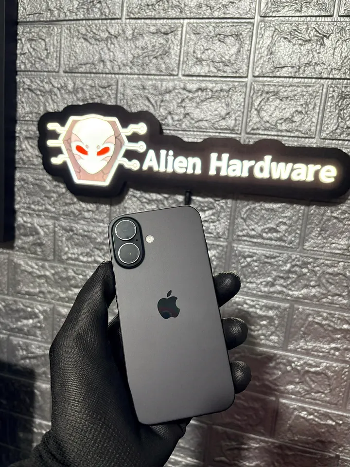 iPhone 16 preto segurado com luva preta em frente ao letreiro da loja